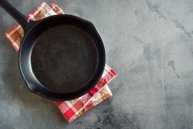 Cast iron pan on rustic grey concrete background close up -  empty black frying pan frying skillet with copy space