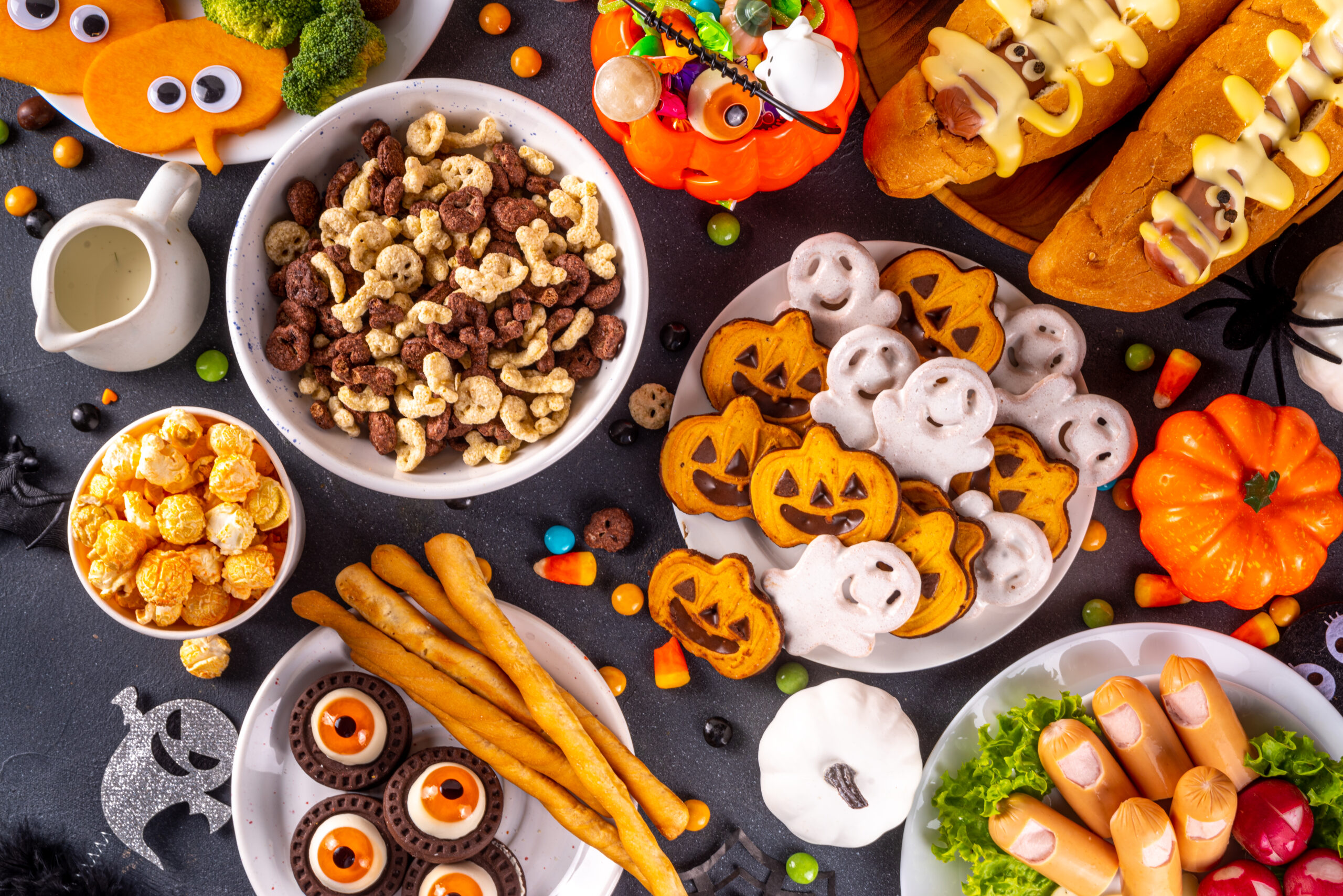 Halloween monster food and snack assortment. Set of funny creative food for children Halloween party, children brunch or breakfast - cookies, healthy and fast food snacks, breakfast cereals, hot dogs