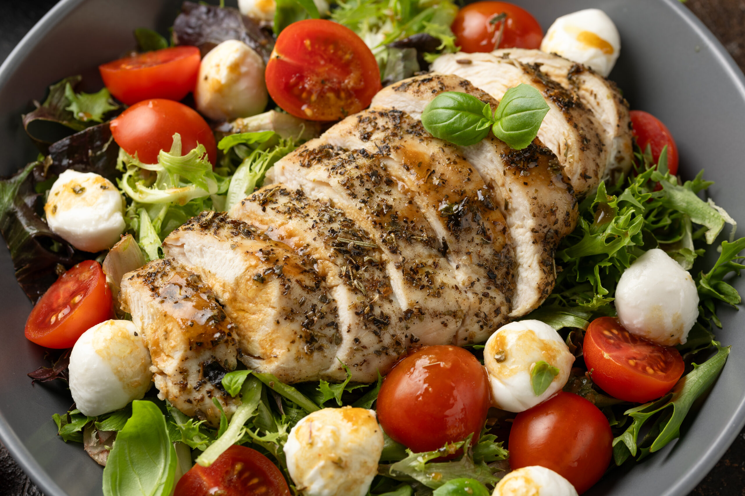 Chicken caprese salad with tomato, mozzarella and balsamic dressing.